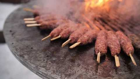 Turkish kebab is cooked on a circular grill in the open air. Stock-Footage 229556606