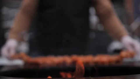 Turkish kebab is cooked on a circular grill in the open air. Video stock 229556622
