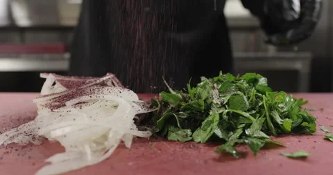 Turkish kebab side dish onion salad preparation. Chef adds spices to chopped Stock Footage 273282947