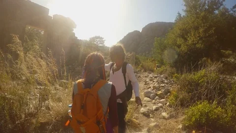 Turkish long-haired man and a girl with a backpack and dreadlocks in the ruins Stock Footage 81740057