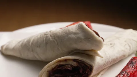 Turkish meat doner kebab wraps rotating with tomato and grilled pepper Stock Footage 333570731