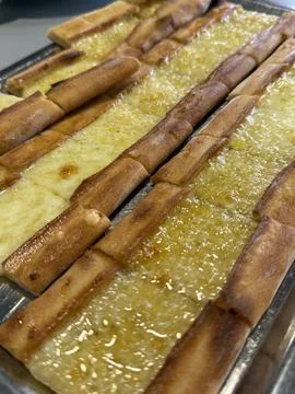 Turkish pide bread topped with melted cheese neatly arranged on a metal tra.. Stock Photos