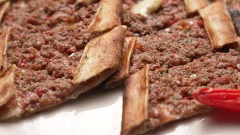 Turkish pide with minced meat, served with red pepper on a white plate Stock Footage 338391019