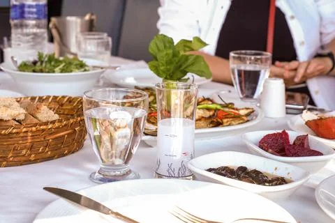 Turkish raki and appetizer table with grilled fish and salad Foto stock