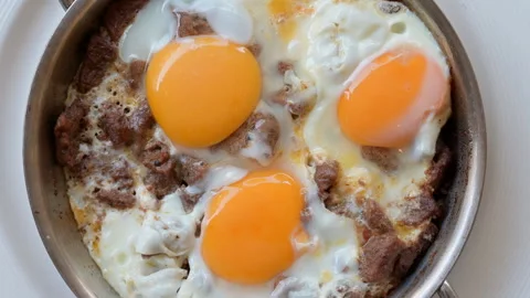 Turkish scrambled eggs with roasted meat in copper pan Video stock 260453445