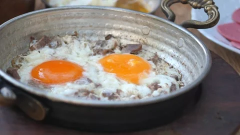 Turkish scrambled eggs with roasted meat in copper pan Video stock 262502800