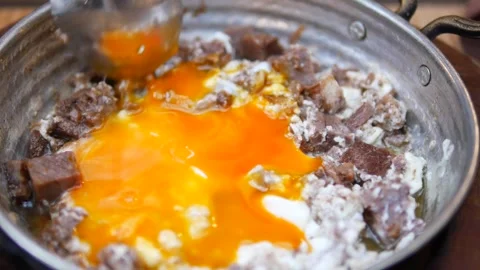 Turkish scrambled eggs with roasted meat in copper pan Video stock 273848855