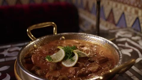 Turkish Stew in Metal Pan on Patterned Table at Traditional Restaurant Interior Stock Footage 345277358