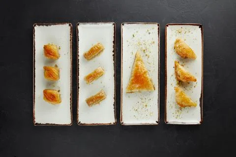 Turkish sweets stacked in a row on rectangular plates Stock Photos