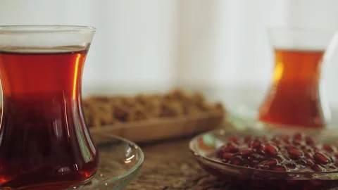 Turkish tea and sweets, hot drink in traditional slim-waisted glass close-up. Stock Footage 241429792