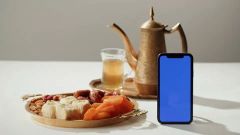 Turkish tea and sweets, smartphone with blue chroma key screen, hot drink in Stock Footage 198210371