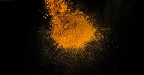 Turmeric, curcuma longa, Powder Exploding against Black Background, Indian .. Foto stock