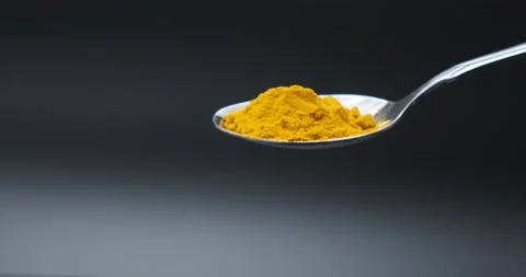 Turmeric falling in slow motion from spoon Stock Footage 148951042