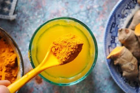 Turmeric powder and paste prepared with fresh turmeric root in the kitchen Stockfoto's