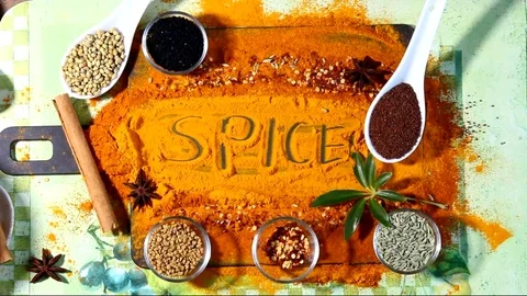 A Turmeric powder background with Indian spices and text Spice Stock Footage