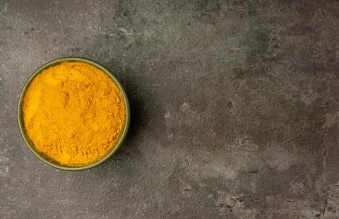 Turmeric Powder from a flat lay angle with a dramatic dark background. Stock Photos