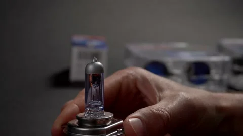 Turn on and turn off halogen bulb for car in hand. Car component Stock Footage 161275103