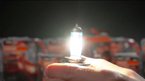 Turn on halogen bulb for car in hand. Car component Stock Footage 161275018