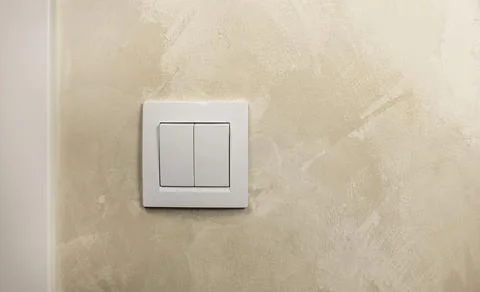 Turn the light on or off. A white light switch on the wall. Stock Photos