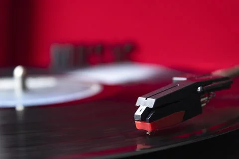 Turn table needle playing a LP vinyl disc with turn table and red background Stock-Fotos