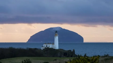 Turnberry Lighthouse and the Ailsa Craig at sunset - 2 Stock Footage 147126897