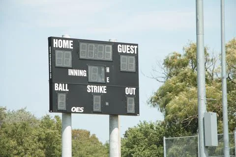 Turned off baseball electronic digital scoreboard on posts in outfield with time Stock Photos