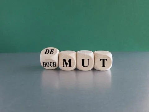 Turned cube and changes the German expression Hochmut to demut Stock Photos
