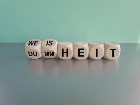 Turned cubes and changes the German word Dummheit to Weisheit Stock Photos