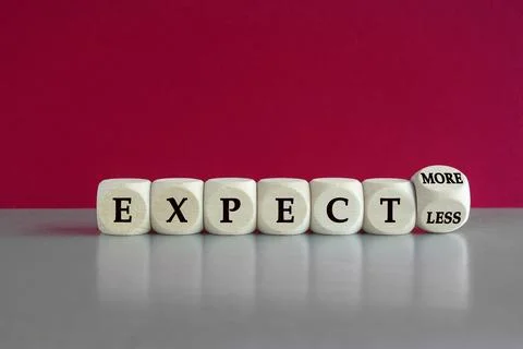 Turned dice and changes the expression Expect less to Expect more. Stock Photos