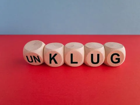Turned dice and changes the German word unklug (stupid) to klug (smart). Foto stock