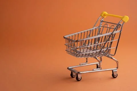 Turned pushcart empty on orange background, Black Friday concept. Stock Photos