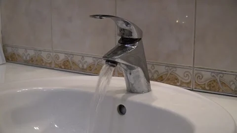 Turned on the tap in the bathroom. Clear, clean water flows from the tap Stock Footage 241452624