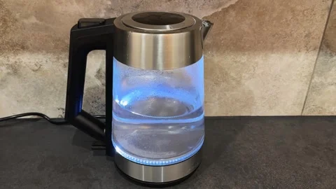 Turned on transparent electric kettle with blue backlight Stock Footage 342277853