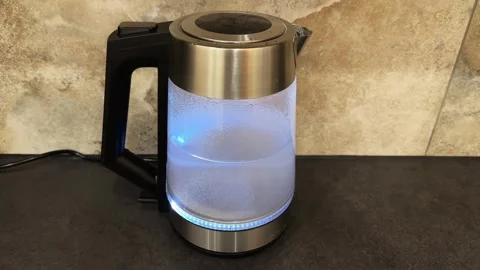 Turned on transparent electric kettle with blue backlight Stock Footage 342277869