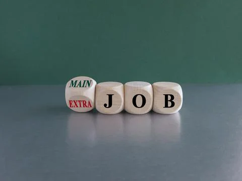 Turned a wooden cube and changes concept red words Extra job to Main job. Stock Photos
