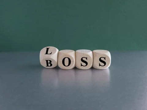 Turned wooden cube and changes the words LOSS to BOSS. Stock Photos