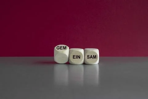 Turned a wooden cube and changes the German word einsam to gemeinsam Stock Photos