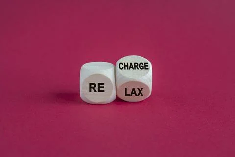 Turned a wooden cube and changes the word 'relax' to 'recharge'. Foto stock