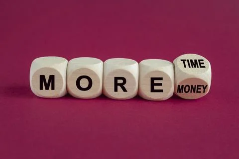 Turned a wooden cube and changes the inscription 'more money' to 'more time' Stock Photos