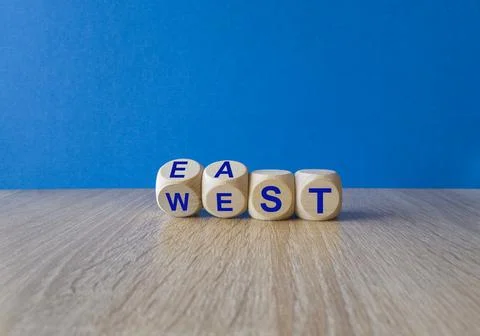Turned wooden cubes and changes the word east to west, or vice versa. Stock Photos