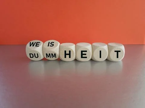 Turned wooden cubes and changes the German word Dummheit to Weisheit Stock Photos