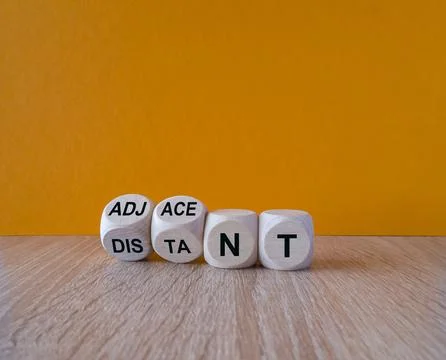 Turned wooden cubes and changes words Distant to Adjacent. Stock Photos
