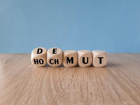 Turned  wooden cubes and changes the expression Hochmut to demut Stock Photos