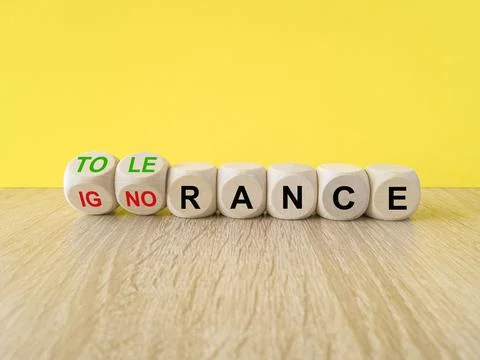 Turned wooden cubes and changes the word ignorance to tolerance. Stock Photos