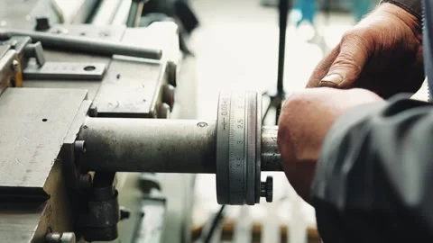 Turner mechanic set up the lathe before work by turning the setting knob with Stock Footage 284545042