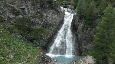 Turning aerial front view of Val Nera waterfall in Livigno Stockbeeldmateriaal 256218065
