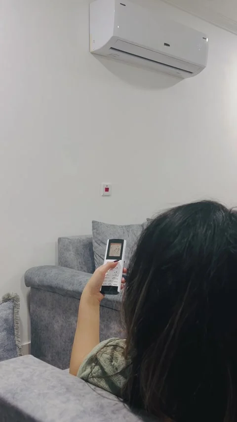 Turning on the air conditioner with remote, Vídeos de archivo 336848583