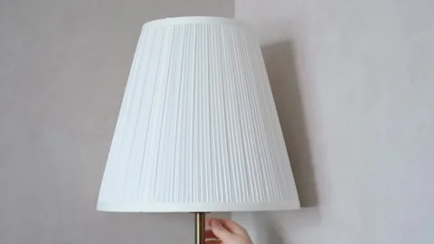 Turning on and off the light on a white floor lamp close-up on a gray background Stock Footage 336170128