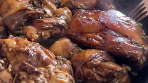 Turning and stirring chicken pieces in a frying pan Stock Footage 276331502