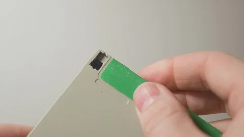 Turning off and on the write-protect lock tab on a floppy disk Stock Footage 101271774
